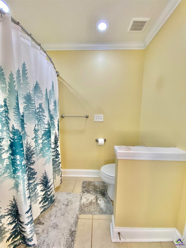 bathroom with tile patterned flooring, crown molding, and toilet