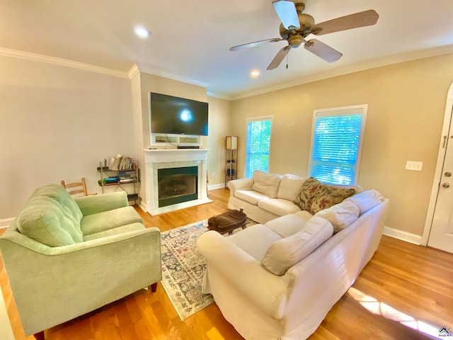 living room featuring light hardwood / wood-style flooring, ceiling fan, and ornamental molding