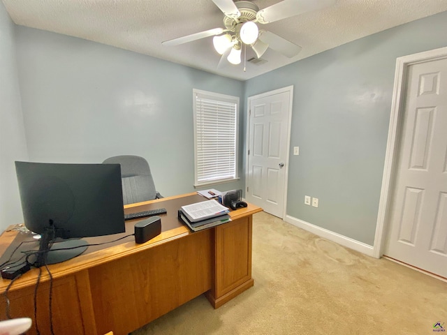 office area with light carpet, ceiling fan, and a textured ceiling