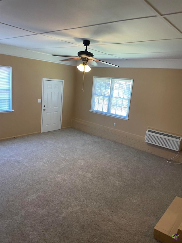 carpeted spare room with ceiling fan, a wealth of natural light, and a wall mounted air conditioner