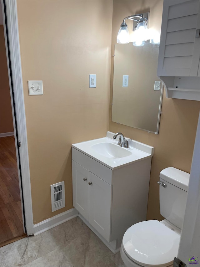 bathroom with hardwood / wood-style floors, toilet, and vanity