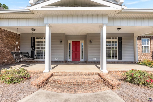 view of exterior entry featuring covered porch