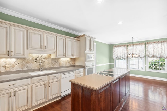 kitchen featuring pendant lighting, sink, white appliances, cream cabinetry, and dark hardwood / wood-style flooring