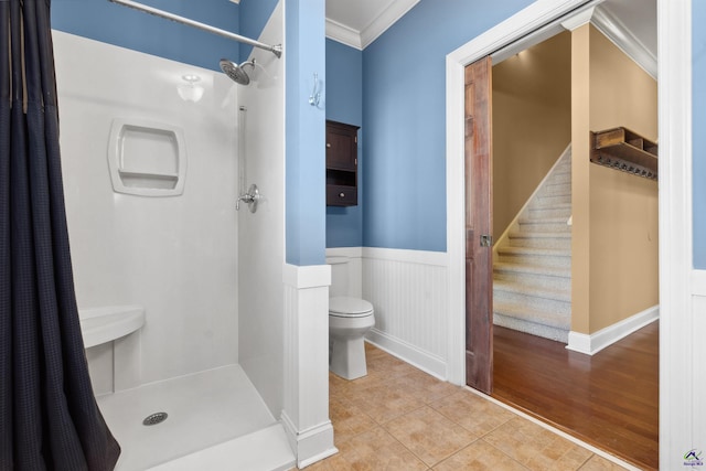 bathroom with hardwood / wood-style floors, crown molding, toilet, and a shower with curtain