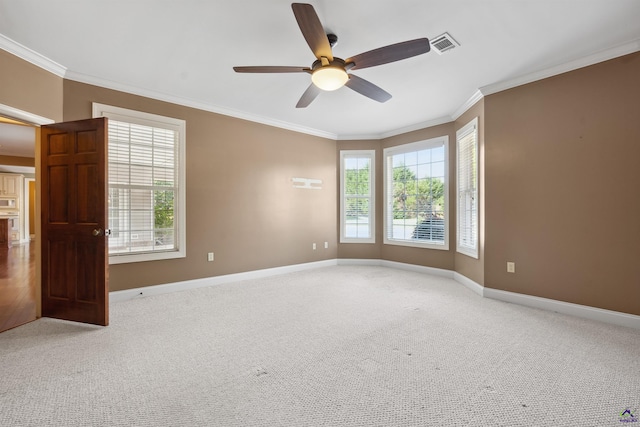 carpeted spare room with ceiling fan and crown molding