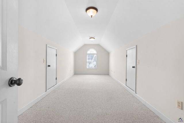 additional living space with light carpet and vaulted ceiling