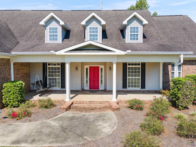 cape cod house featuring covered porch