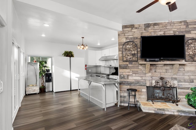 kitchen featuring pendant lighting, white refrigerator, white cabinetry, dark hardwood / wood-style floors, and a breakfast bar