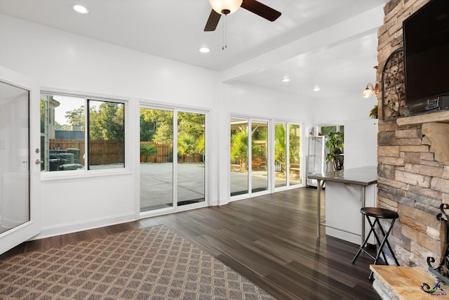 unfurnished sunroom with ceiling fan