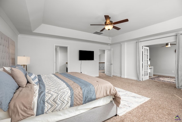 bedroom with ceiling fan, a raised ceiling, and carpet