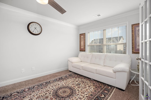 carpeted living room featuring crown molding and ceiling fan