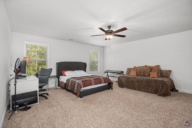 bedroom with light carpet, multiple windows, and ceiling fan