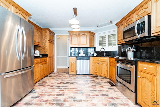 kitchen featuring pendant lighting, sink, tasteful backsplash, appliances with stainless steel finishes, and crown molding