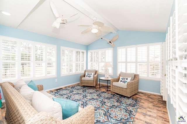 living area with plenty of natural light, ceiling fan, vaulted ceiling with beams, and hardwood / wood-style flooring