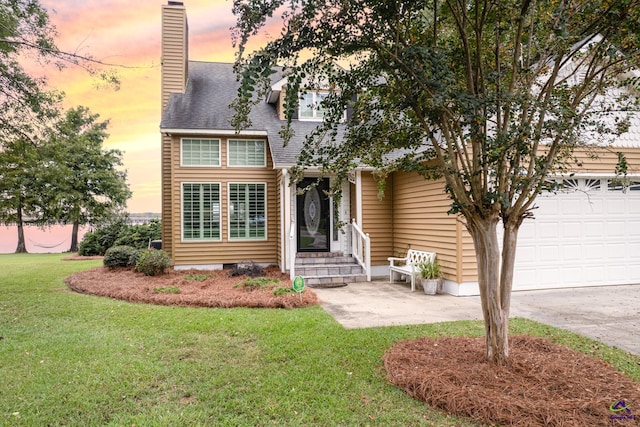 view of front of home with a garage and a lawn