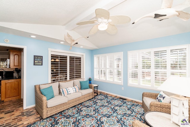 living room featuring vaulted ceiling with beams, a textured ceiling, and ceiling fan