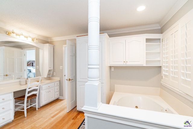 bathroom with crown molding, a washtub, hardwood / wood-style flooring, and vanity