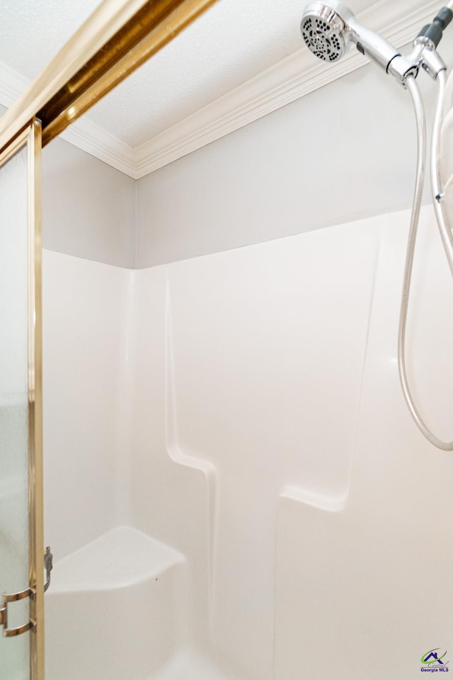 bathroom featuring an enclosed shower and ornamental molding