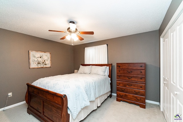 carpeted bedroom featuring a closet, a textured ceiling, and ceiling fan