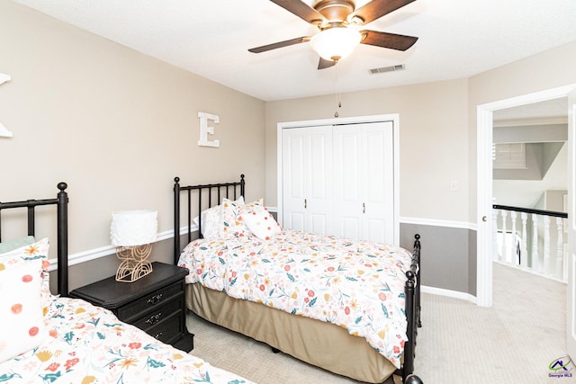 carpeted bedroom with ceiling fan and a closet