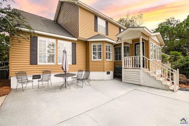 back house at dusk with a patio area