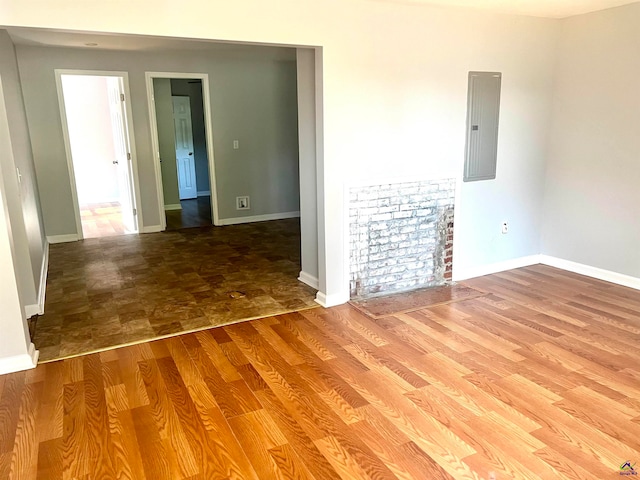 empty room featuring electric panel and hardwood / wood-style floors