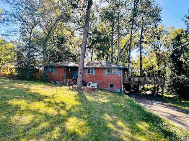 exterior space featuring a wooden deck and a lawn