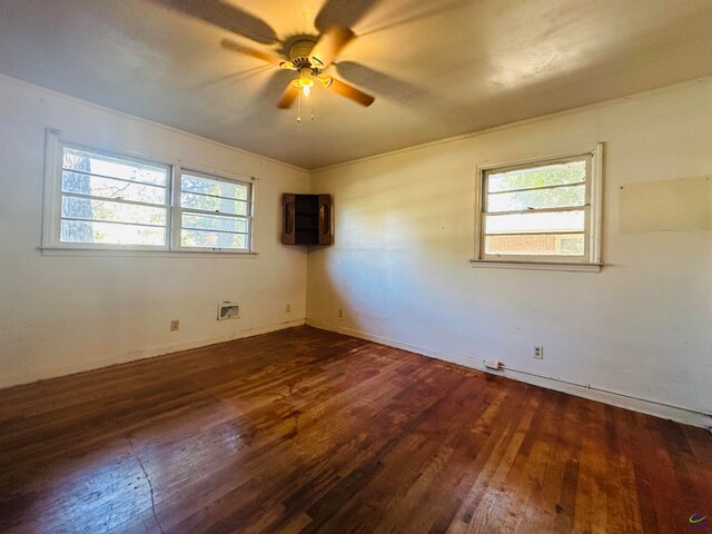 spare room with dark hardwood / wood-style floors, a healthy amount of sunlight, and ceiling fan