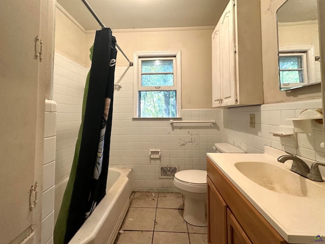 full bathroom featuring toilet, tile patterned flooring, shower / bath combo with shower curtain, vanity, and tile walls