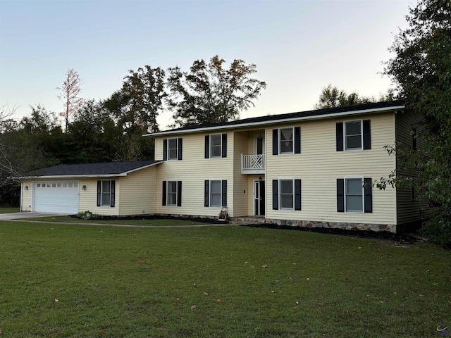 colonial house featuring a front yard, a balcony, and a garage