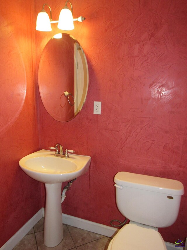 bathroom featuring sink, toilet, and tile patterned flooring