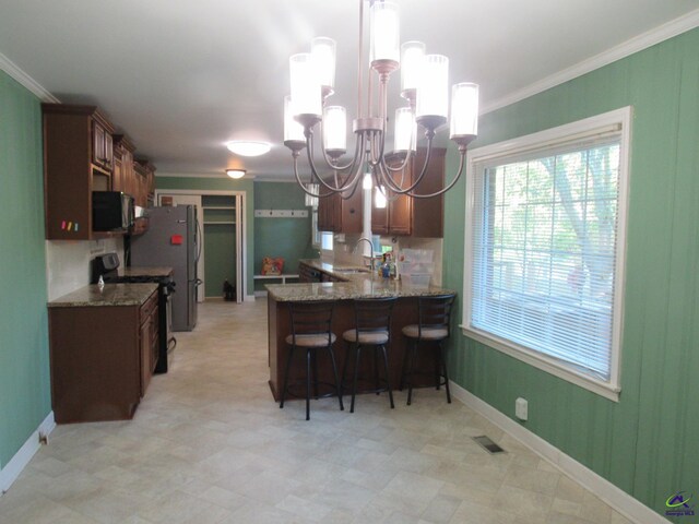 kitchen with kitchen peninsula, black appliances, pendant lighting, a notable chandelier, and sink