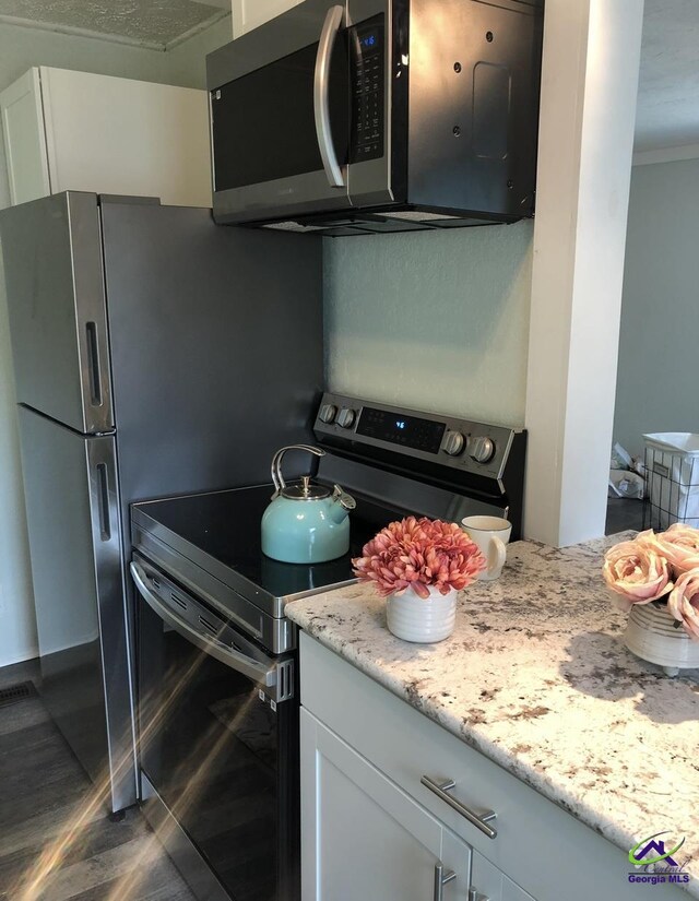 5415 Beulah Ave, Eastman, GA 31023 - kitchen featuring stainless steel appliances, crown molding, white cabinetry, and light stone counters