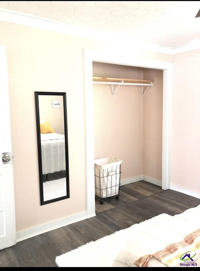 5415 Beulah Ave, Eastman, GA 31023 - unfurnished bedroom featuring dark wood-type flooring, ornamental molding, a closet, and baseboards