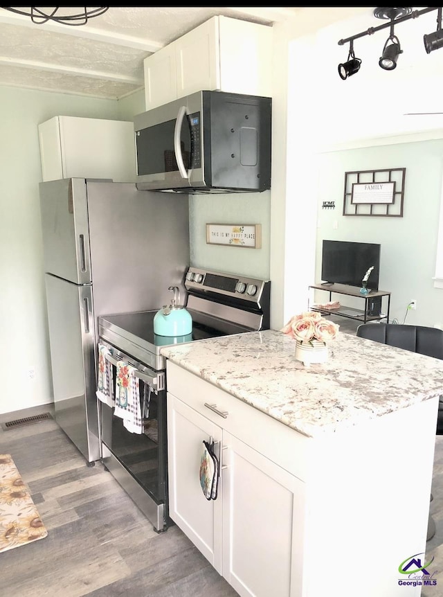 5415 Beulah Ave, Eastman, GA 31023 - kitchen featuring appliances with stainless steel finishes, light wood-style floors, white cabinets, and light stone countertops