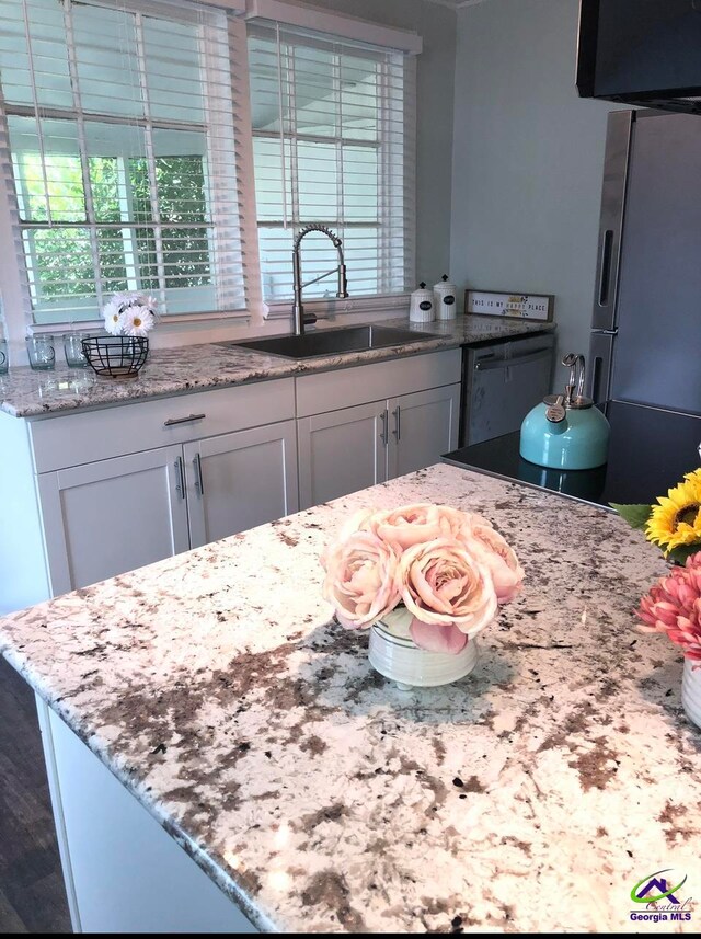 kitchen featuring light stone counters, stainless steel appliances, sink, and white cabinets