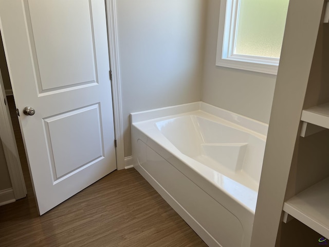 bathroom with hardwood / wood-style flooring and a bathtub