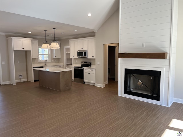 kitchen with a kitchen island, white cabinets, and appliances with stainless steel finishes