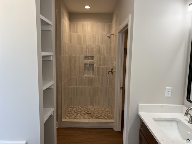 bathroom with vanity and a tile shower