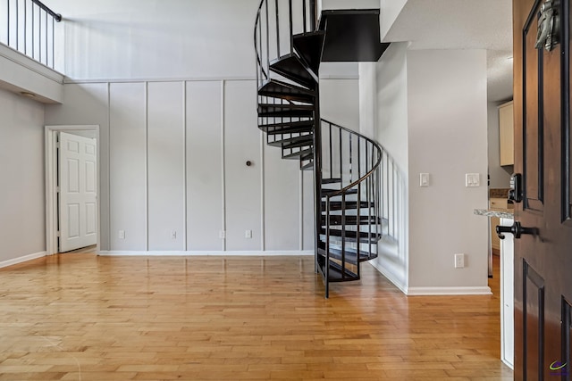 foyer entrance featuring light hardwood / wood-style floors and a high ceiling