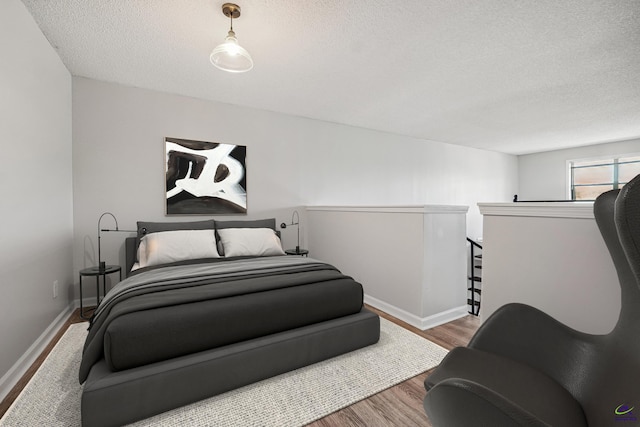 bedroom featuring hardwood / wood-style floors and a textured ceiling