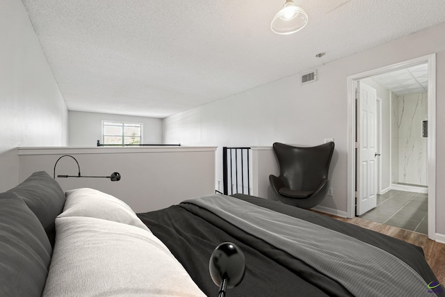 bedroom featuring a textured ceiling and wood-type flooring