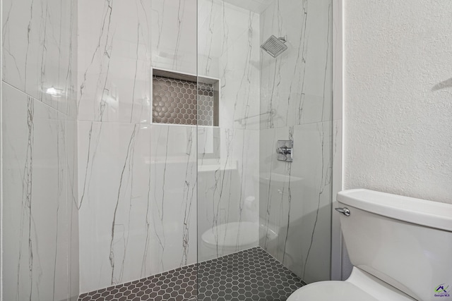 bathroom with toilet and tiled shower