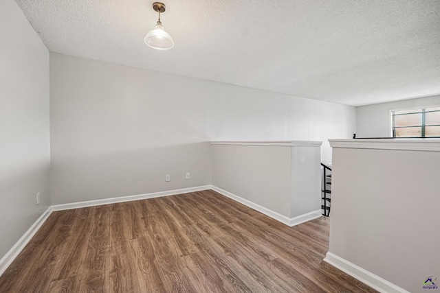 unfurnished room featuring a textured ceiling and wood-type flooring