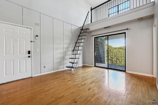 entryway featuring hardwood / wood-style flooring and a high ceiling