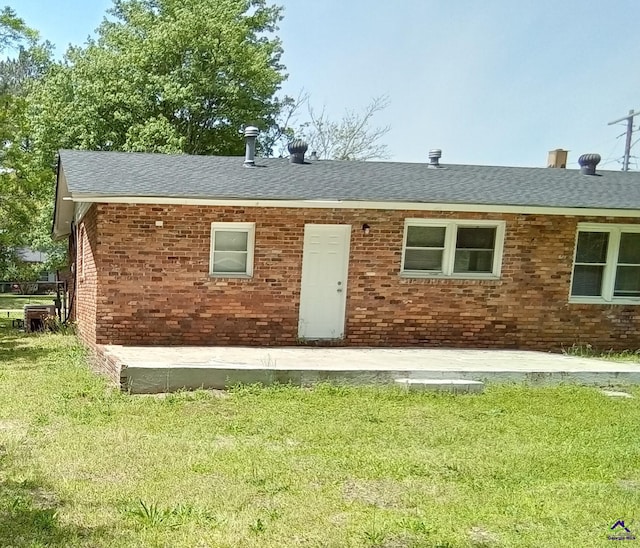 rear view of property with a lawn