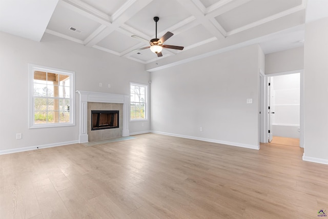 unfurnished living room with light wood finished floors, coffered ceiling, and visible vents