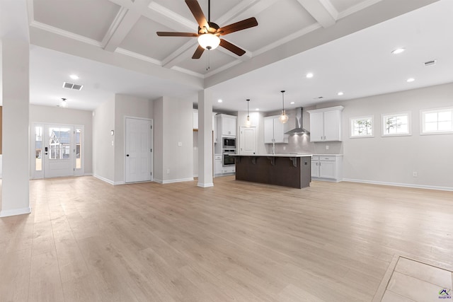 unfurnished living room with coffered ceiling, a ceiling fan, visible vents, baseboards, and light wood finished floors