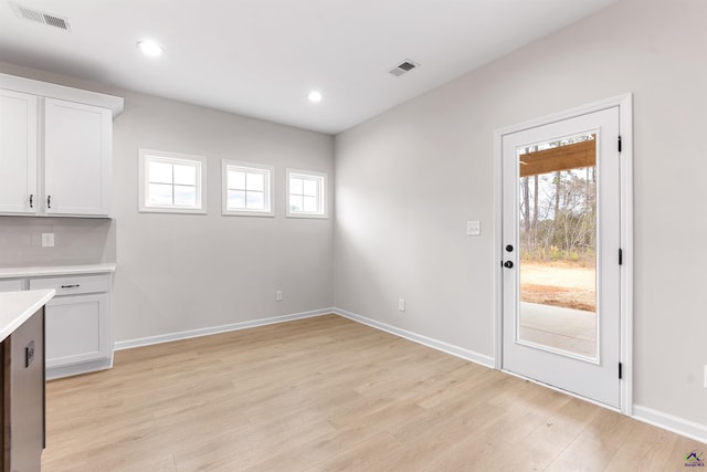 interior space with a healthy amount of sunlight, light wood-style floors, and visible vents