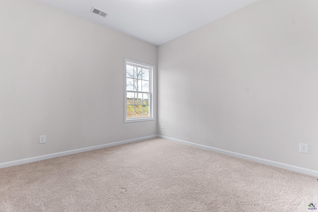 carpeted spare room with visible vents and baseboards